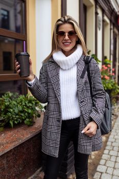 stylish woman Tourist walking around the city with a cup of coffee.