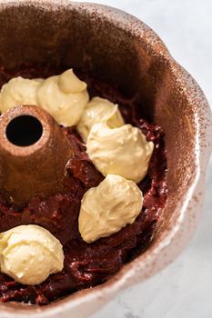 Filling metal bundt cake pan with cake butter to bake red velvet bundt cake with cream cheese glaze