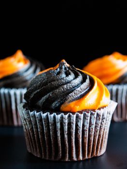 Halloween cupcakes decorated with black and orange swirled icing.