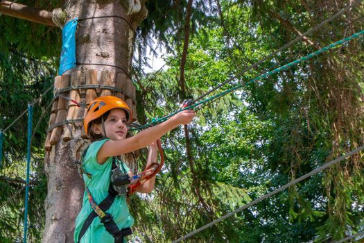 adventure climbing high wire park - people on course in mountain helmet and safety equipment. High quality photo