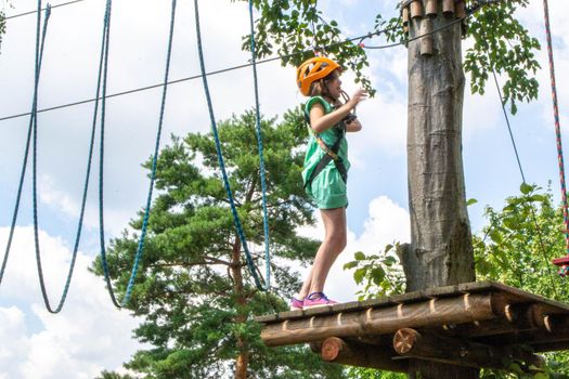 adventure climbing high wire park - people on course in mountain helmet and safety equipment. High quality photo