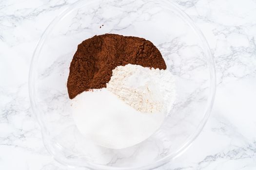 Mixing ingredients in a glass mixing bowl to bake a chocolate cupcake.