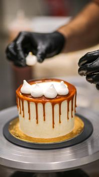chef decorating the top of a frosted buttercream cake