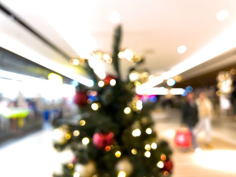 blurred decorated christmas tree in shopping mall background. High quality photo