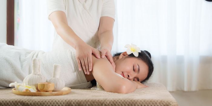 Young woman doing relaxing massage in spa salon. Female being massaged by a masseur. Spa and medicine concept.