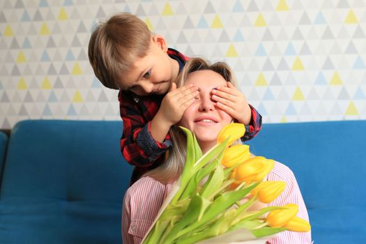 the boy gave flowers to his mother and hugs her. mother's day concept.