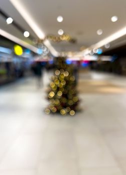 blurred decorated christmas tree in shopping mall background. High quality photo