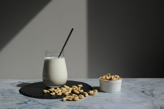 Vegan milk from nuts cashew on the cement table. Vegan or vegetables milk.
