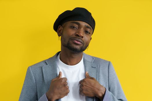 Young african gangster in beret and suit looking in camera with call. Criminal concept. High quality photo