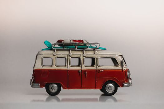 Red and white retro car toy model isolated on white. Toy retro Minivan with surf. Tervuren - November 30 2022
