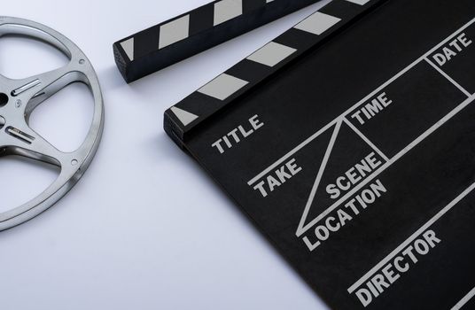 Close up of a vintage clapboard with 8mm filmstrip on white background.