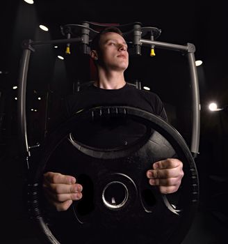 Attractive tall muscular bodybuilder doing heavy deadlifts in moder fitness center, creative photo, contours, muscles stand out, beautiful body, physique, relief, sexy guy, young. High quality photo