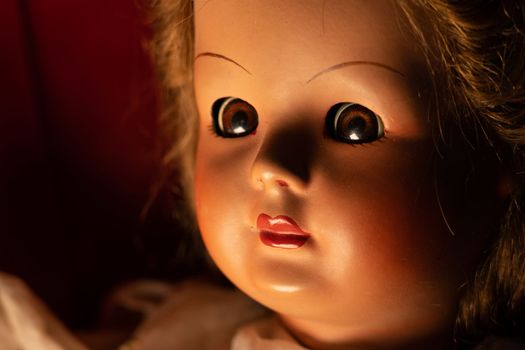 Scary vintage doll in half light. Close up