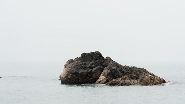 Stone block of rock in the water of the sea. High quality photo