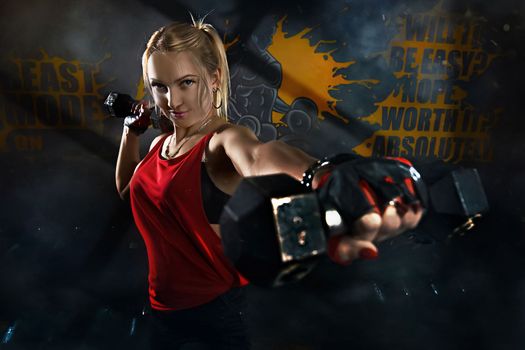 Fitness woman working out in gym doing exercise for biceps. Athletic girl training. Beautiful fitness woman lifting dumbbells . Fitness sporty woman showing her well trained body . A beautiful girl's.