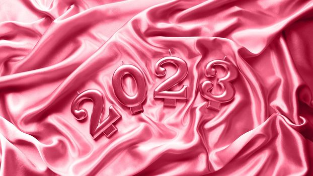 The figures of 2023 lie on a satin background painted in the color of the year 2023