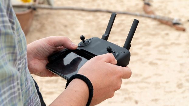 Men's hands hold a joystick to control the quadcopter, videographer, photographer. High quality photo