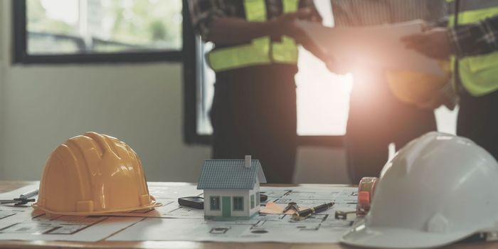 Civil engineer teams meeting working together wear worker helmets hardhat on construction site in modern city. Foreman industry project manager engineer teamwork. Asian industry professional team...