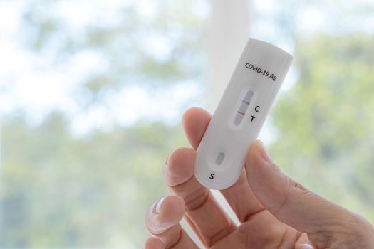 Coronavirus Covid-19 antigen test with positive result with human hand.