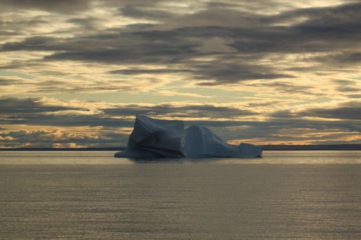 Stranded iceberg and ice near evening in arctic landscape, near Pond Inlet, Nunavut, Canada