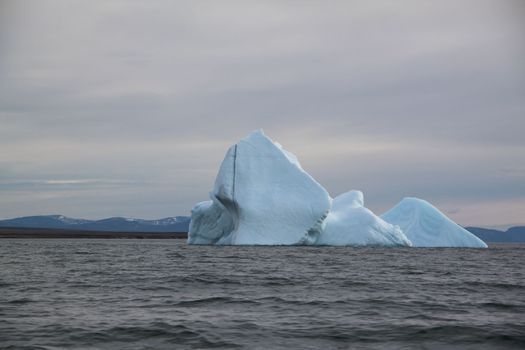 Stranded iceberg and ice near evening in arctic landscape, near Pond Inlet, Nunavut, Canada