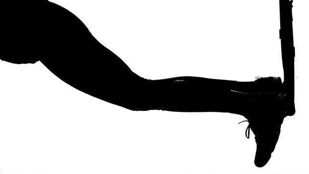 on a white background, a shadow, a black outline of a female figure doing exercises. High quality photo