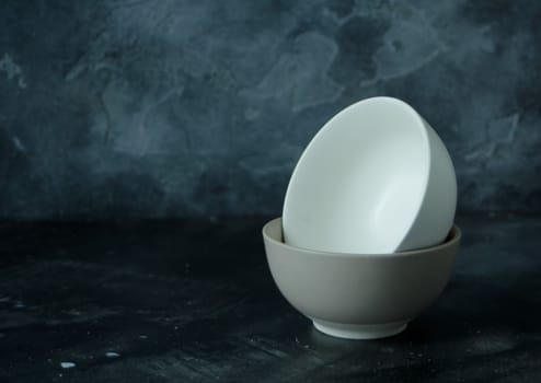 Two empty ceramic bowls in dark background