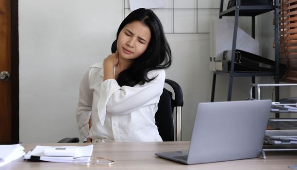 Tired female employee holding head on hand, looking at computer screen, doing hard task, having problem with computer software. Stressed exhausted businesswoman suffering from headache, feeling bored