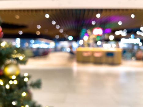 blurred decorated christmas tree in shopping mall background. High quality photo