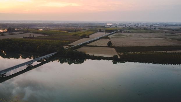 sunset over a bridge in the river in autumn