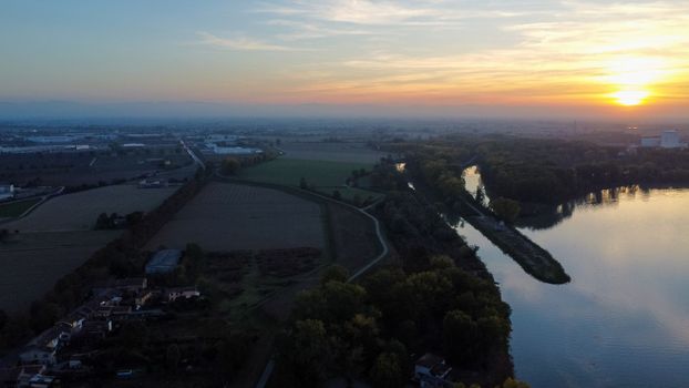 sunset over a bridge in the river in autumn