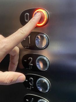 finger press elevator button with light. Going up to ground floor.
