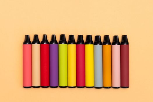 Assortment of disposable e-cigarettes on a light background. Nicotine vapor system, Alternative smoking system, top vew.