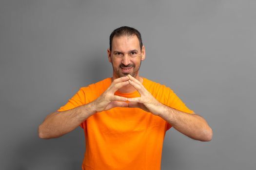 Evil genius, scheming man, making plans, looking cunning and thoughtful, mastermind idea, tipping fingers while thinking, standing against gray background