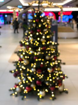 blurred decorated christmas tree in shopping mall background. High quality photo