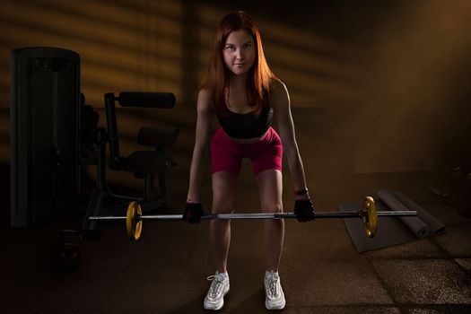 Strong woman doing weights.Sports lifestyle Beautiful fitness woman lifting dumbbells . Fitness sporty woman showing her well trained body. A beautiful girl's body with rippling muscles from strength training. High quality photo
