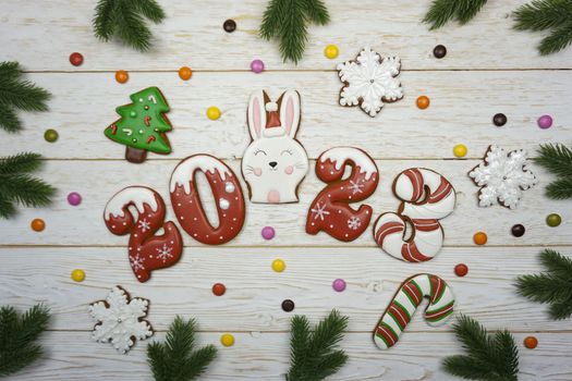 Gingerbread cookies are laid out on a wooden table. The numbers 2023 are made of gingerbread. Gingerbread in the form of numbers, snowflakes, Christmas trees.