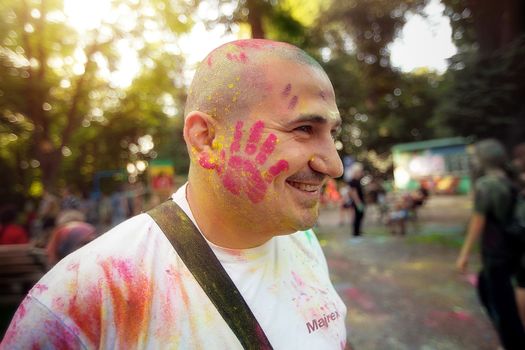 Young people, teenagers and adults celebrate the Holi event in Ukraine in Chernivtsi on March 8 in 2022. They have fun and throw paint at each other. High quality photo
