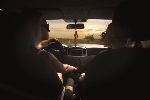 sexy and skinny girls eat in the car away from the bustle of the city, best friends are free and enjoy the journey. High quality photo