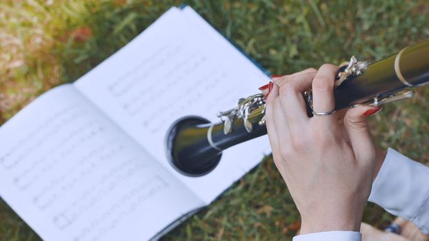 The girl plays the clarinet by notes