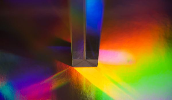 Glass prism on bright rainbow colors abstract background. Colorful polygonal multicolor banner. High quality photo