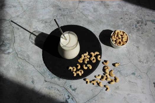 Vegan milk from nuts cashew on the cement table. Vegan or vegetables milk. Top view.