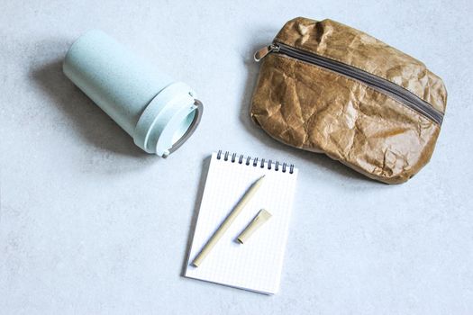 Pen, bag and cardboard cup made of recycled paper. Environmentally friendly stationary supplies. Eco friendly modern ecological biomaterials. Plastic pollution reduction concept. Zero waste concept.