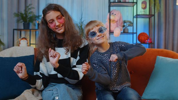 Teenage little sisters child kids recording blog creative trendy dance challenge moves for social media account. Female siblings children or friends at home play room. Friendship, family relationship