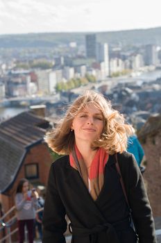 portrait of a beautiful young blonde girl with flying hair in the sun against the backdrop of a big city. High quality photo