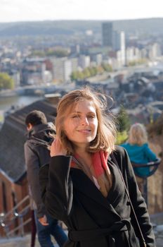 portrait of a beautiful young blonde girl with flying hair in the sun against the backdrop of a big city. High quality photo