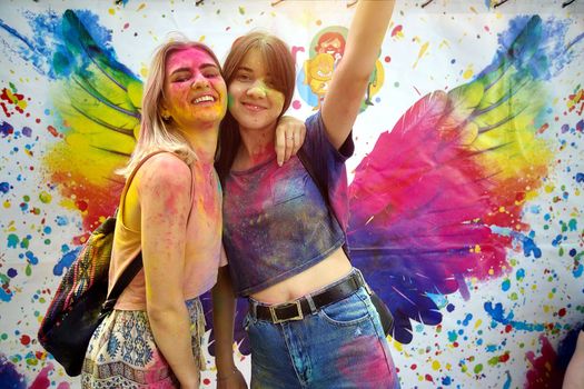 Young people, teenagers and adults celebrate the Holi event in Ukraine in Chernivtsi on March 8 in 2022. They have fun and throw paint at each other. High quality photo
