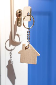 Opening door to a new home with key and home shaped keychain - Mortgage, investment, real estate, property and new home concept. High quality photo