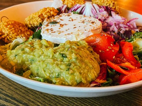 Close up of colorful salad over wooden table.