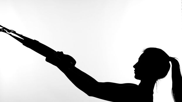 on a white background, a shadow, a black outline of a female figure doing exercises. High quality photo